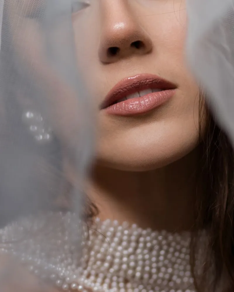 Close-up of a bride with clear, radiant skin and a pearl necklace